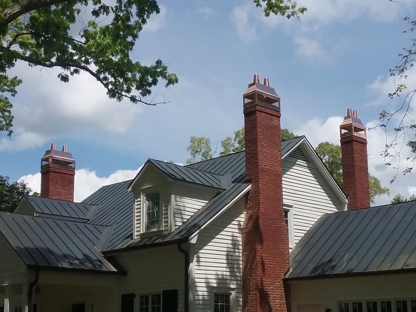 Standing seam roof with chimney caps